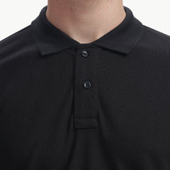 ADEL & VIDA black Onyx polo shirt with a classic collar and button placket, worn by a model in a studio setting.