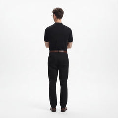 ADEL & VIDA black regular fit polo shirt worn by a model from the back view, paired with black trousers.