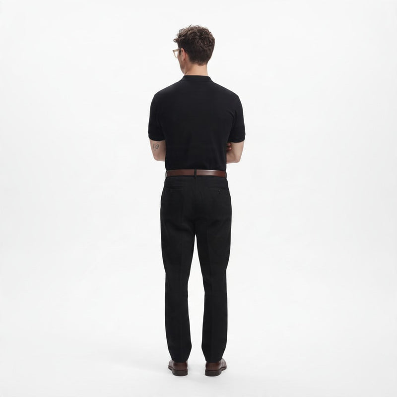ADEL & VIDA black regular fit polo shirt worn by a model from the back view, paired with black trousers.