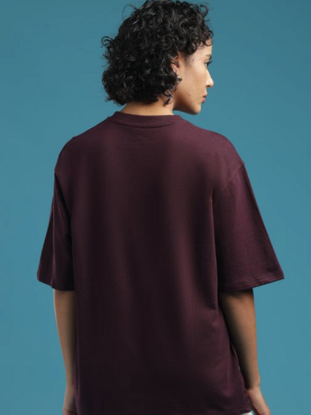 Model wearing an ADEL & VIDA oversized burgundy t-shirt with a soft, breathable finish, back view