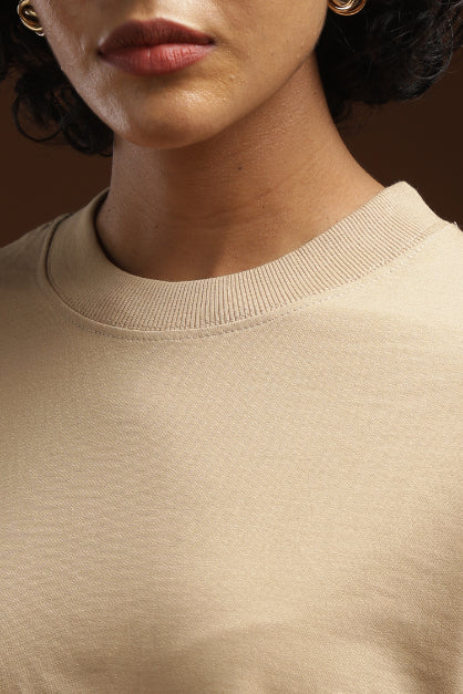 ADEL & VIDA beige oversized crew neck t-shirt with soft ribbed collar detail on a model