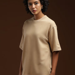 ADEL & VIDA Dune State oversized beige t-shirt worn by a model with curly hair against a dark brown background
