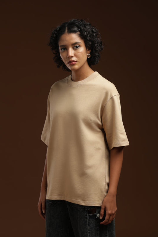 ADEL & VIDA Dune State oversized beige t-shirt worn by a model with curly hair against a dark brown background
