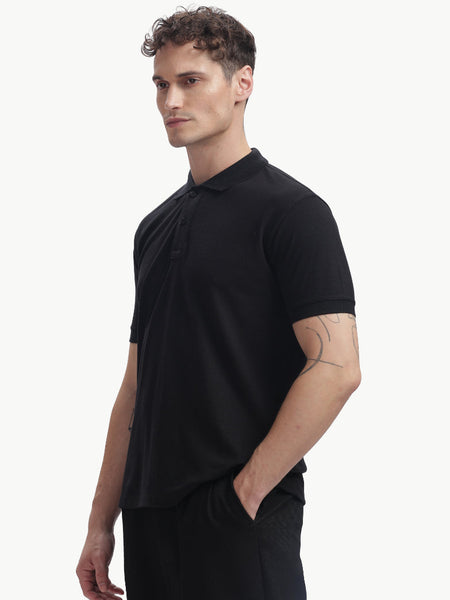 ADEL & VIDA Onyx black regular fit polo t-shirt worn by a model, featuring a soft, breathable, and stretchable fabric.