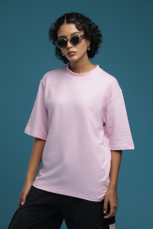 ADEL & VIDA oversized baby pink t-shirt worn by a model with sunglasses against a blue background