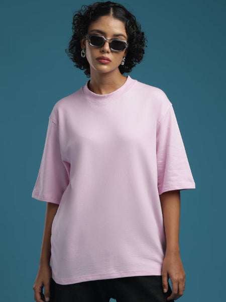 Model wearing an ADEL & VIDA oversized baby pink t-shirt with a crew neck, styled with sunglasses.