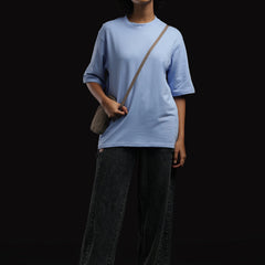ADEL & VIDA Azure Horizon oversized sky blue t-shirt worn by a model with sunglasses and a crossbody bag