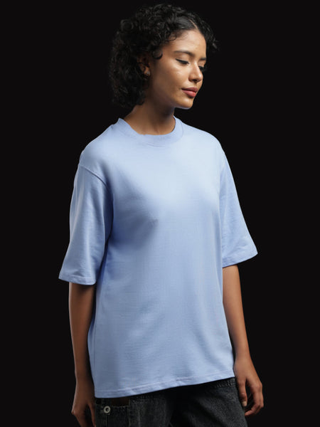 ADEL & VIDA Azure Horizon oversized sky blue t-shirt worn by a model with short curly hair against a black background